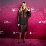 Heidi Klum wearing a sheer black blouse and skirt at the Infinite Icon premiere in Los Angeles