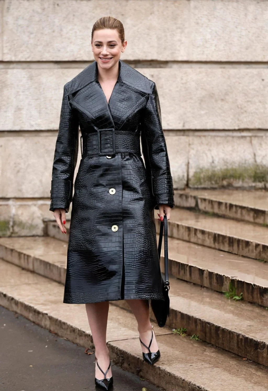 Lili Reinhart wearing a croc-embossed black trench coat at the Patou Menswear Fall-Winter 2026-2027 show during Paris Fashion Week.