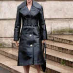 Lili Reinhart wearing a croc-embossed black trench coat at the Patou Menswear Fall-Winter 2026-2027 show during Paris Fashion Week.