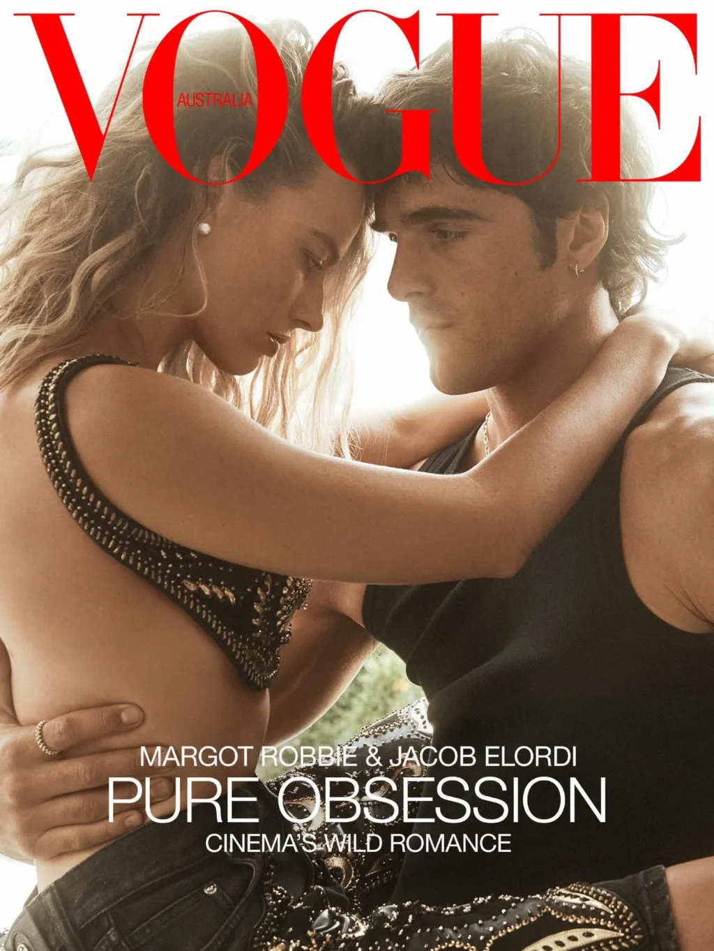 Margot Robbie wears a Versace bralette and shorts; Paspaley earrings. Jacob Elordi wears a Supreme x Hanes tank top; Versace jeans; Cartier earrings, necklace and ring.
