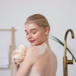 Close up smiley woman holding bath sponge